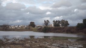 Panoramic video of lake with residential buildings and mountains in background