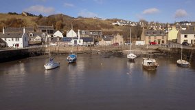 Aerial footage of Gourdon village and fishing harbour on a sunny day, Aberdeenshire, Scotland