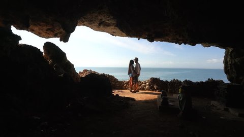 Traveler couple people enjoy amazing aerial view from cave on top of mountain on tropical beach. Summer vacation, Travel and Active LifeStyle concept in 4k