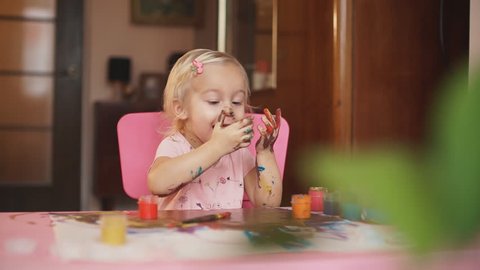 Little girl with hands in paint