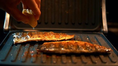Chef Pouring Lemon Juice On Grilled Fish.Lemon Juice On Mackerel Steak Seafood On Grill Barbecue.Chef Cooking Grilled Sardines With Lime. Frying Fish Dishes Scomber On Home Kitchen.Healthy Food No Fat