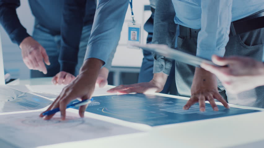 Engineer, Scientists and Developers Gathered Around Illuminated Conference Table in Technology Research Center, Talking, Finding Solution and Analysing Industrial Engine Design. Shot on 8K RED  | Shutterstock HD Video #1025767436