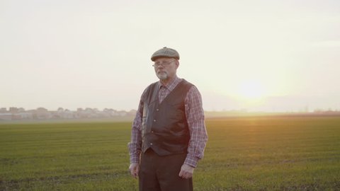 Portrait of confident senior farmer looksa at camera with crossed hands