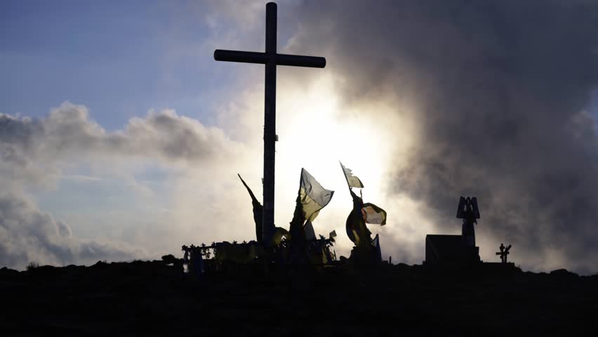 Cross and flags on mountain top 