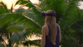 Closeup shot of a beautiful young woman use a VR headset in a tropical park. A person wearing a vr glasses feels like he is in tropics. Augmented reality concept - Powered by Shutterstock - Get 15% off with code: PIKWIZARD15