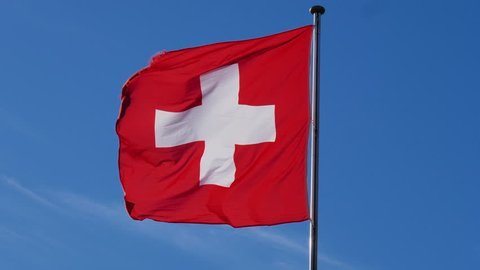 swiss flag waving in wind at sunny day on cliffs of Sissacher Flu. CH Switzerland