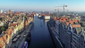 Gdansk, Poland. Motlawa River, old houses, medieval port crane (Zuraw) and new modern quarter in traditional style under construction on the Granary Island ruined in the II World War. Aerial video