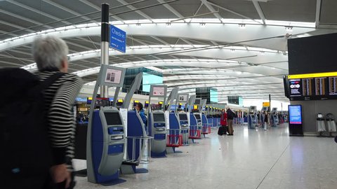 HEATHROW AIRPORT, LONDON - MARCH 16, 2019: British Airways passengers using self service check in kiosks inside the departures level at Terminal 5, Heathrow International Airport in London, UK.