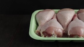 raw chicken legs package close view tracking shot