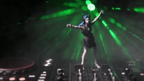 Dj club concept. Woman DJ mixing, and Scratching in a Night Club. Girl silhouette on dj's deck, strobe lights and fog on background. Creative artwork decoration with toy. Selective focus - Powered by Shutterstock - Get 15% off with code: PIKWIZARD15