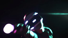 Close-up modern move controller in hand, young girl wearing VR headset gesturing hand in space on dark background illuminated neon lights - Powered by Shutterstock - Get 15% off with code: PIKWIZARD15