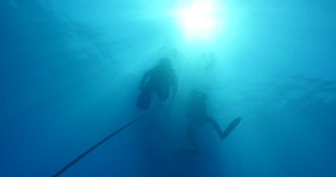 scuba diver on the rope of dive boat sun shine sun beams and rays underwater ascent descent scenery 