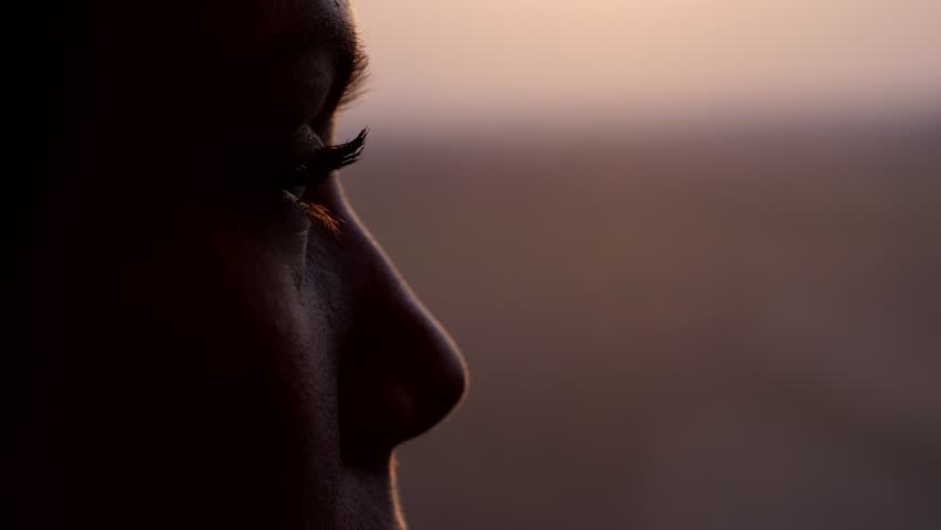 Woman thinking and looking out from train window, extreme close up shot of her eye. Blurred background, dim natural light at evening time. High speed carriage run fast, slow motion shot Royalty-Free Stock Footage #1025854565