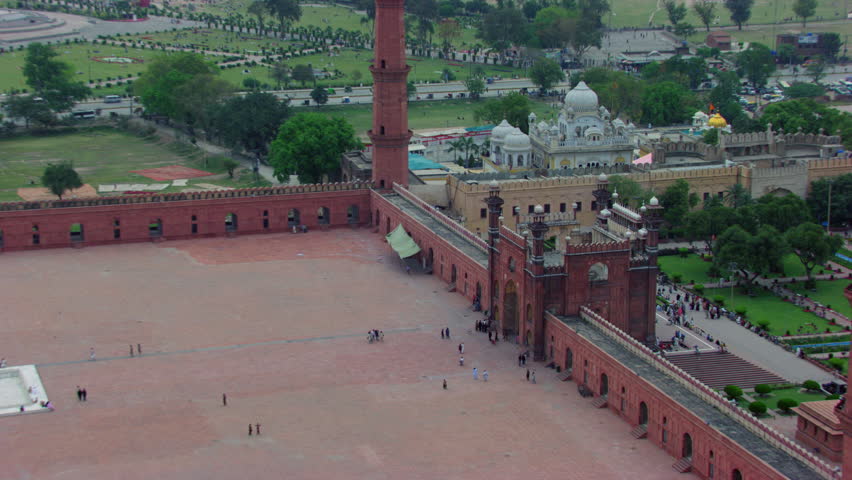 Lahore, Pakistan, Badshahi Mosque aerial view by the minarets, Showing Gurdwara of the Sikhs, street and city traffic, Visitors ladies, gents and children are in the Mosque