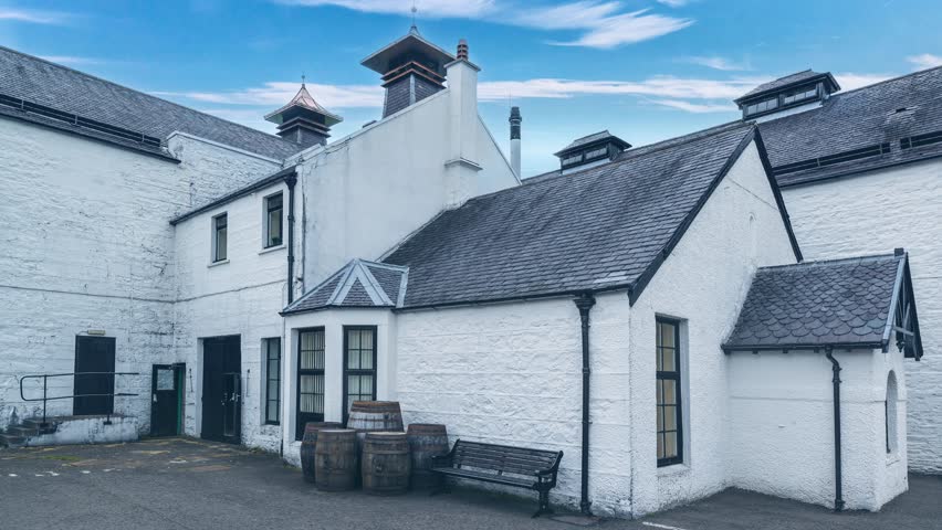 White buildings of a Scottish whisky distillery against great blue sky