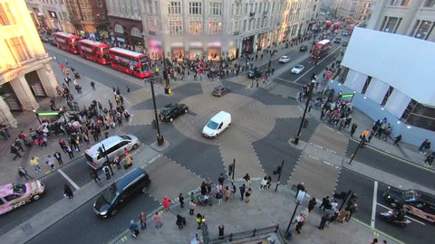 Time lapse of Oxford circus and regent street junction with rush hour traffic of both pedestrians, cars and Red double deck buses.
