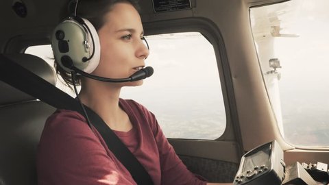 Young girl piloting a small plane through turbulence talking on intercom