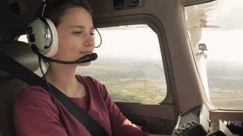 Young confident woman piloting a small civilian plane