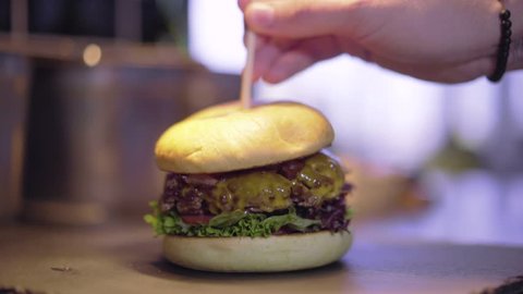 Mini burger being pierced by a toothpick