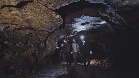 People with headlamps exploring cave