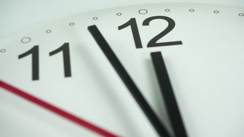Closeup White clock face beginning of time 12.00 am or pm, with Black numbers and arrows, Red second hand minute walk slowly,  stock footage Time concept.