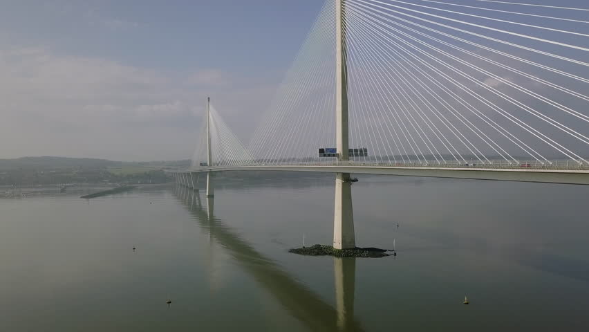 Aerial footage of traffic travelling across the Queensferry Crossing bridge at South Queensferry on a sunny day in West Lothian, Scotland