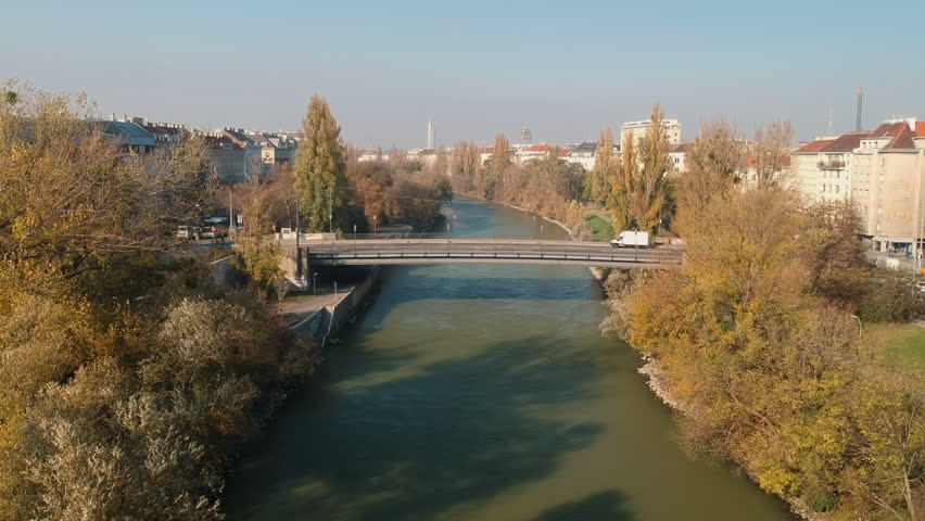 AERIAL Drone shot: cars driving over a bridge in Vienna. Cityscape with the Danube channel / Donaukanal