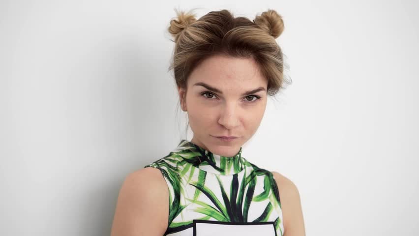 Beautiful young hipster girl with a haircut laughs posing and looks into the camera