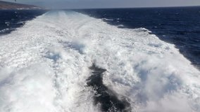 Water trail foaming behind a ferry boat in Atlantic ocean between Canary islands, Spain. Ferry from Fuerteventura island (on the background) to Gran Canaria. FullHD video