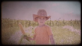 Little boy in a straw hat with a corncob in his hands. Home video. Retro. Vintage. Little cowboy in a cornfield. Organic food. Vegetarianism. Natural products. Child health. Happy childhood.