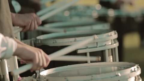 Closeup of hands playing snare drum in drumline in slow motion