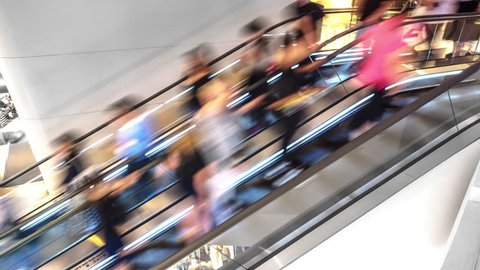 Motion of blurred people on escalator in modern interior. Abstract urban scene