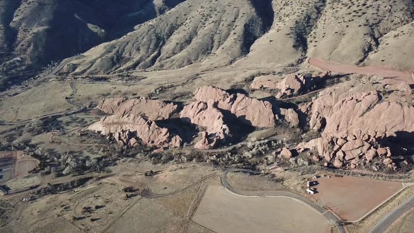 AERIAL: high push over and tilit away from the giant boulders located at the Red Rocks Park in Colorado.