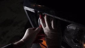Man repair headlight on the old classic car at night.