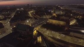 4K. Aerial view of the church and the royal palace in the old town of Warsaw at night time. Drone shot 4k. Video format RAW.