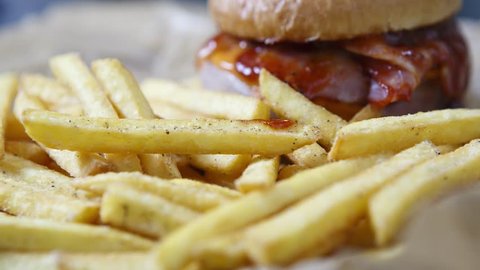 Footage of delicious hamburger with tomato ketchup sauce served on plate with golden French fries in fast food cafe menu.Video of restaurant dinner food in close up.Roasted hand crafted burger
