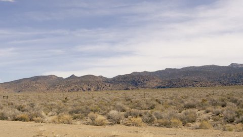 Passing sagebrush flat with barren hills in distance in the Nevada desert along the Great Basin Highway, US Highway 93-Drive Plate-POV
