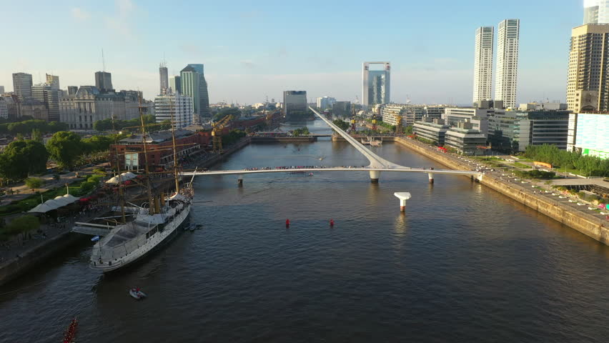 Aerial drone view of Puerto Madero harbor with Puente de la Mujer bridge and skyscraper buildings in the background. Buenos Aires, Argentina.