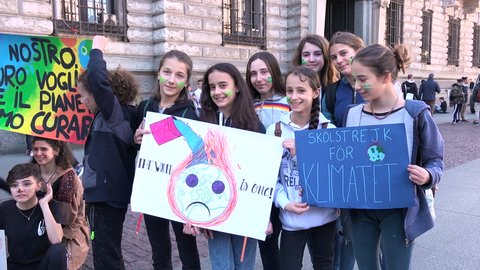 MILAN, ITALY - MARCH 15, 2019: Smiling children with picket signs at global strike for climate. Beautiful kids at Friday for future, little girls next generation at environmentalist demonstration
