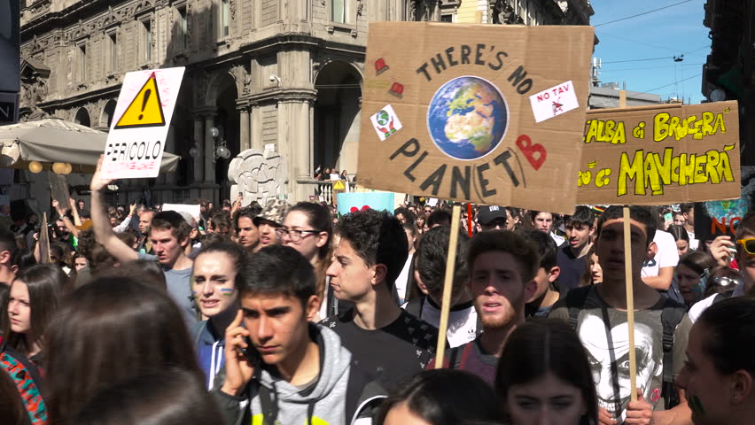 MILAN, ITALY - MARCH 15, 2019: Demonstration of picketers walking at global strike for climate. Students with picket signs, crowd at Friday for future movement, people at ecology parade, green ideals