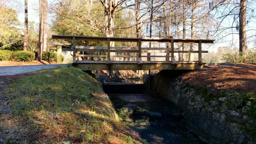 Wooden bridge over dried stream. // Pan shot