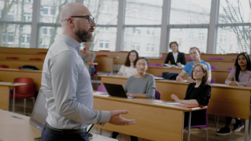Lecturer and multinational group of students in an auditorium Royalty-Free Stock Footage #1025986655