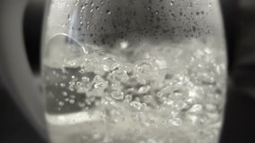 Close-up view of Boiled Water in Glass Kettle. Slow Motion Video Clip
