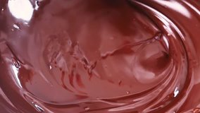 Melted dark chocolate. Mixing melted chocolate with a whisk. Liquid of hot chocolate. Confectionery. Confectioner prepares dessert.