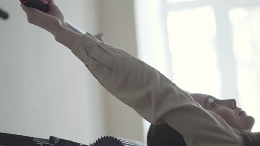 Young girl hang on the machine for pull own skeleton