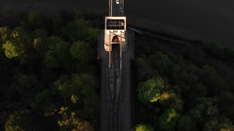 Aerial: Birds Eye of Car Driving Over Clifton Suspension Bridge Bristol City England at Sunset
