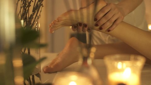 A thai masseur slowly massaging feet with oil.