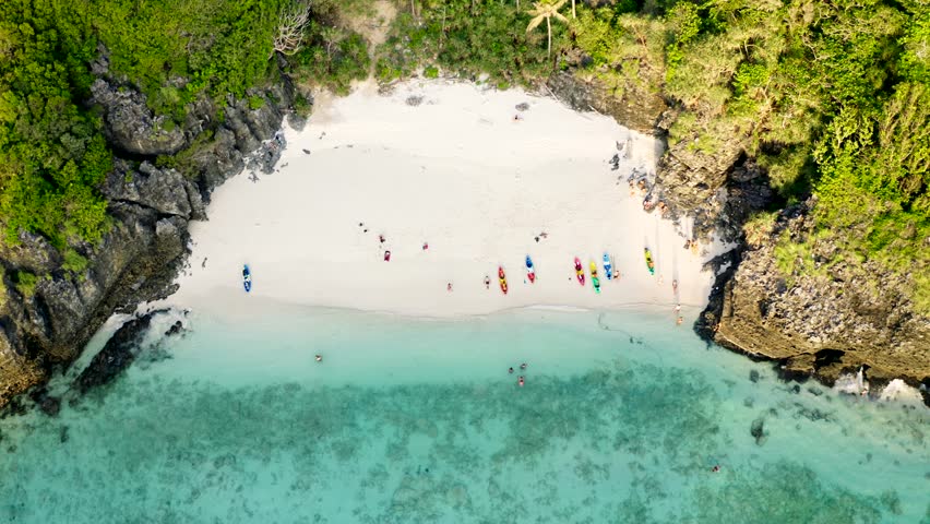 Drone shot of Nui Beach in Koh Phi Phi Islands with people on kayaks and longtail boats