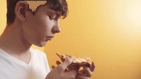 Pizza. happy teen boy eating a slice of pizza concept. teenage boy hungry eats a lifestyle slice of pizza. slow motion video. pizza fast food concept