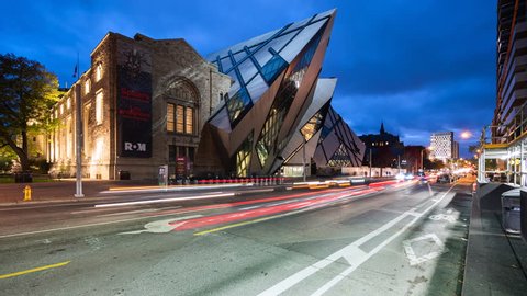 Toronto, Canada - October 24, 2018: Time lapse view of traffic in front of the Royal Ontario Museum aka ROM, the largest and most-visited museum in Canada, at dusk in Toronto, Ontario, Canada.